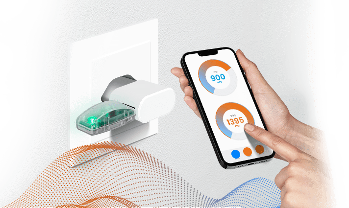 An environmental sensor plugged into a wall socket with someone controlling the sensor using a smart phone.